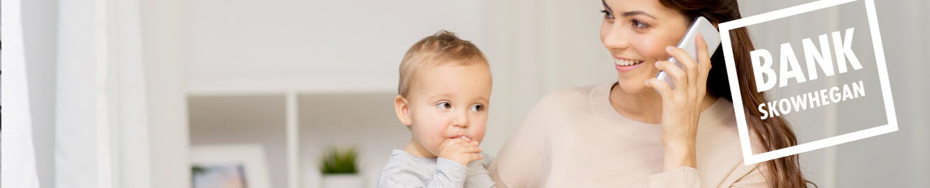 Woman on the phone holding a baby with text saying, "Bank Skowhegan"